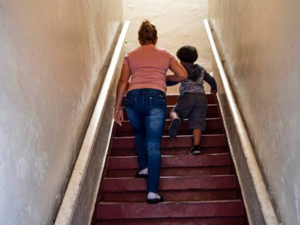 Una inmigrante no identificada que huyó de El Salvador en 2015 sube las escaleras con su hijo en su apartamento en Los Ángeles. 'Hay muchachos adolescentes que, si no hubieran sido deportados, estarían vivos', dijo la mujer, cuyo primo Marcos González fue asesinado en su país natal después de ser deportado por Estados Unidos. Foto: AP