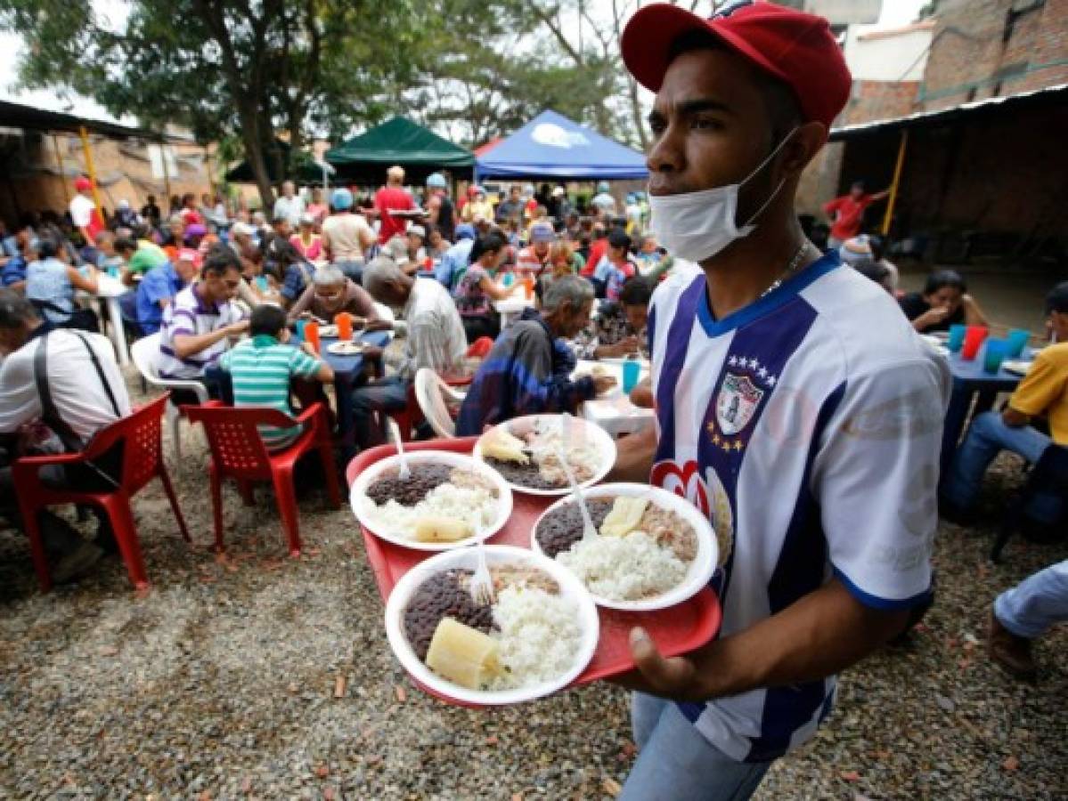 Un voluntario de diócesis de Cúcuta, sirve alimentos a los migrantes venezolanos. Foto: Fernando Vergara | Agencia AP.
