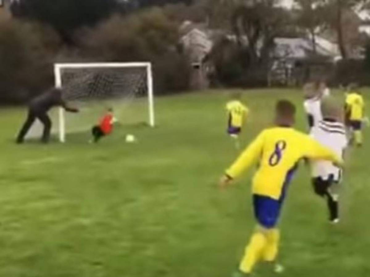 Padre empuja a su hijo de seis años para atajar un gol