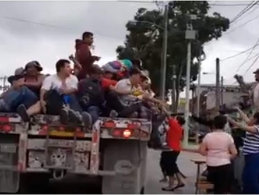 Los hondureños viajan sobre una rastra hacia la frontera de Guatemala con México.