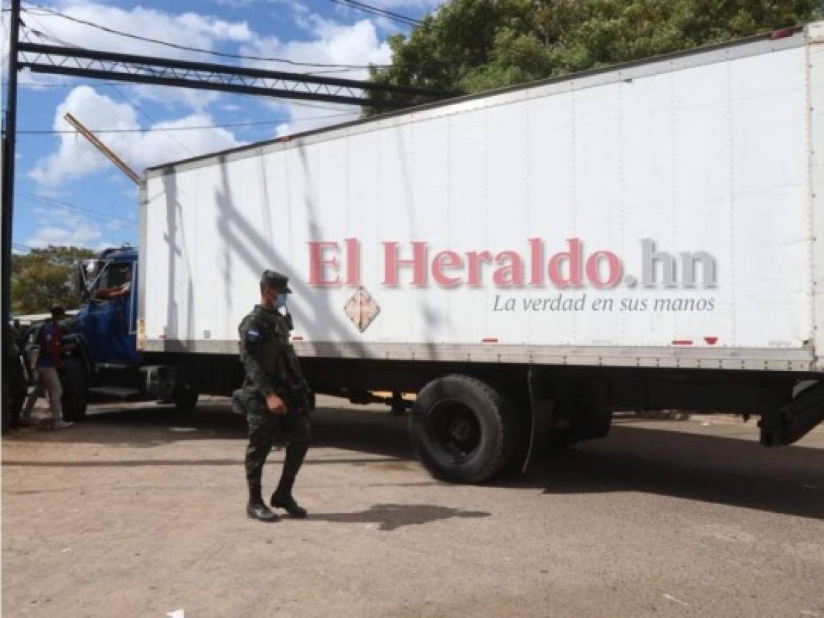 Empleados temporales del CNE descargan las maletas provenientes de Francisco Morazán.