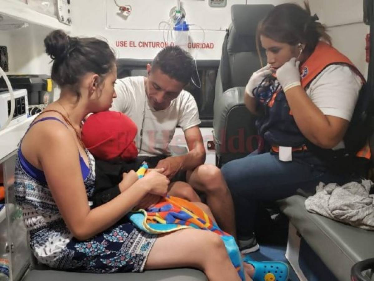 La esposa de Josué Funez, Sarahy Arriola, mientras el personal de Copeco revisaba a su pequeño hijo luego del naufragio. (Foto: El Heraldo)