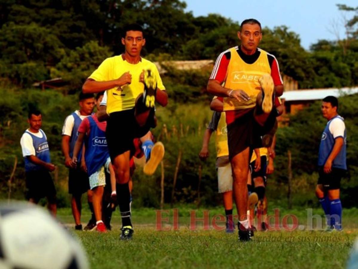 Padre e hijo haciendo trabajos físicos en la práctica vespertina en el campo del municipio.