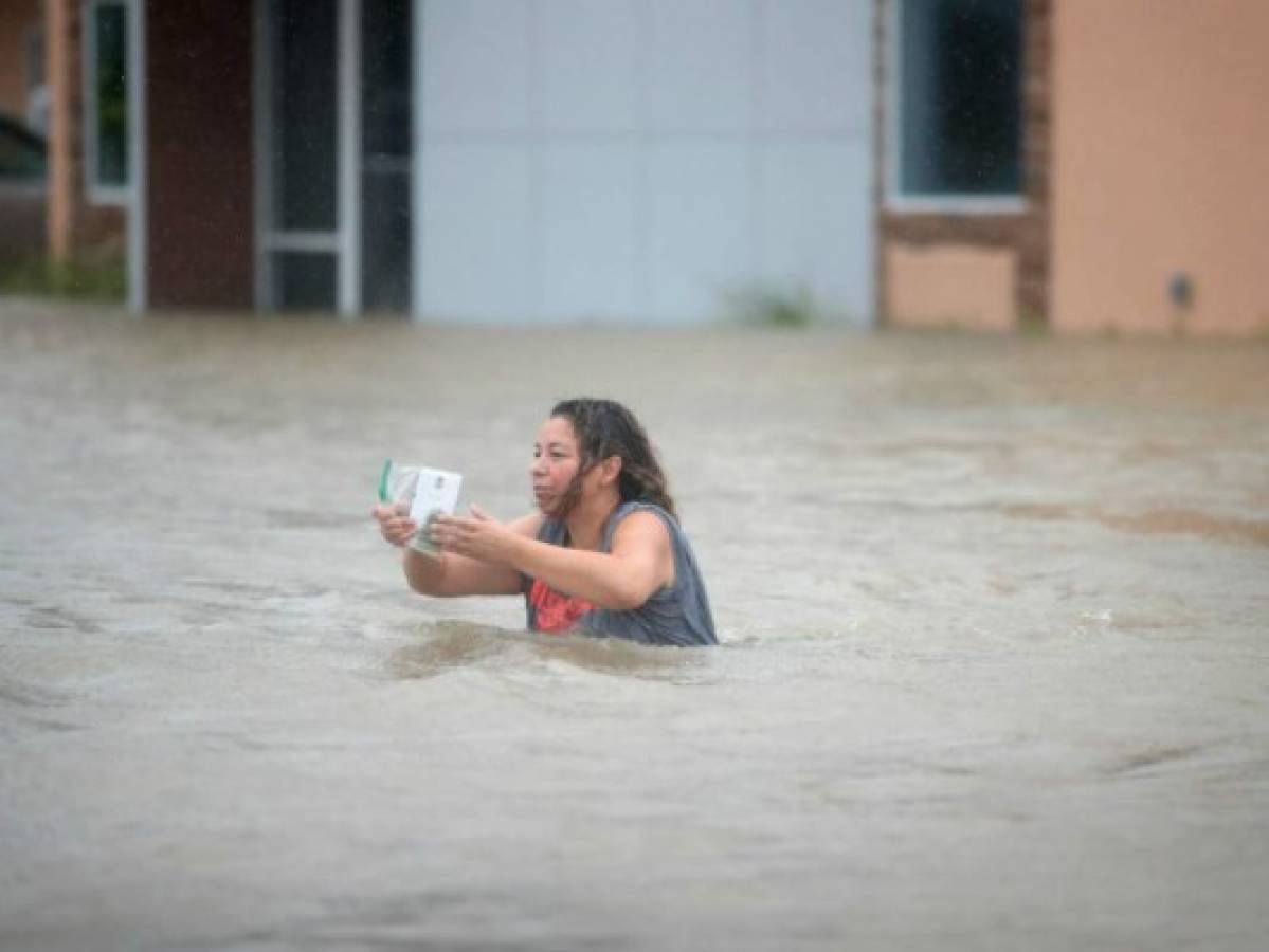 Una mujer cruza la calle completamente inundada.