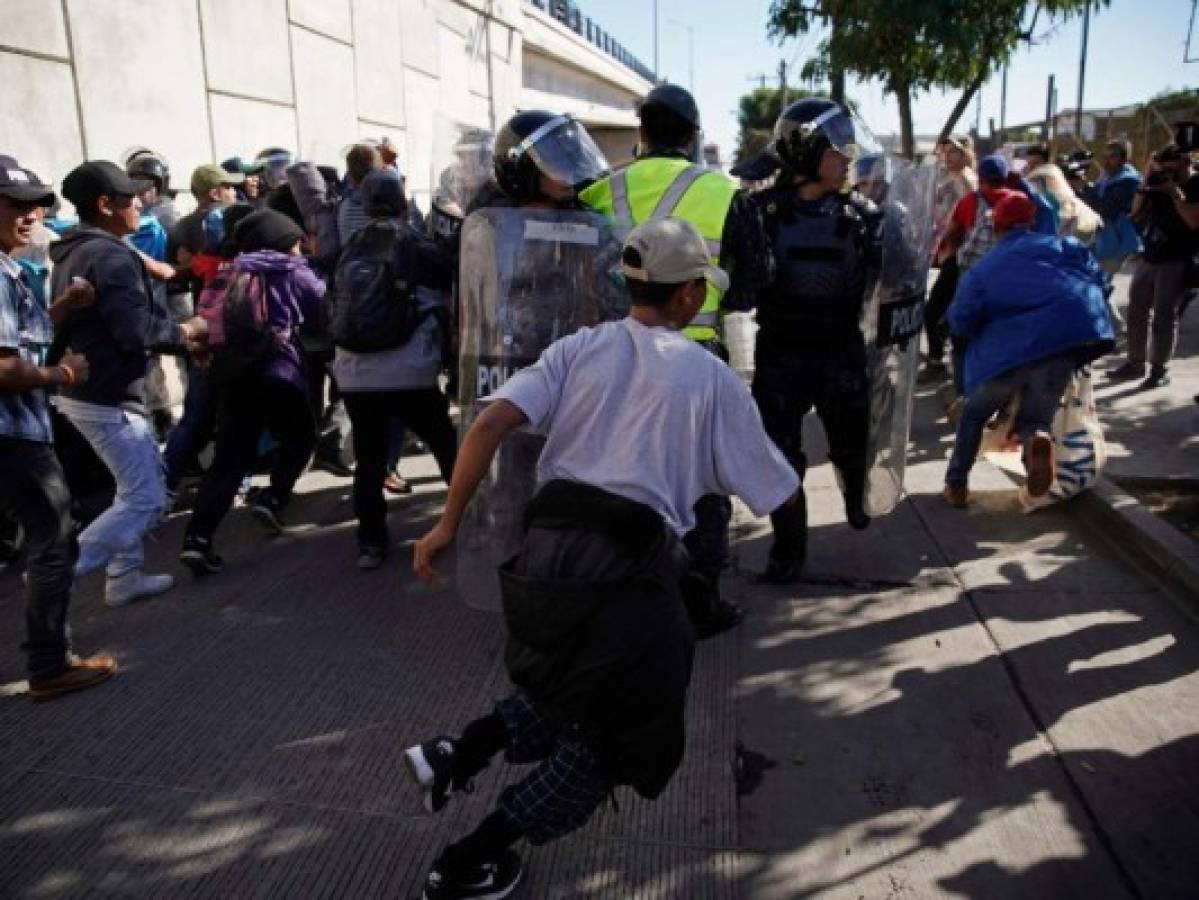 Agentes de EEUU arrojan gas lacrimógeno a miembros de la caravana migrante después que intentaron cruzar por la fuerza la frontera con México
