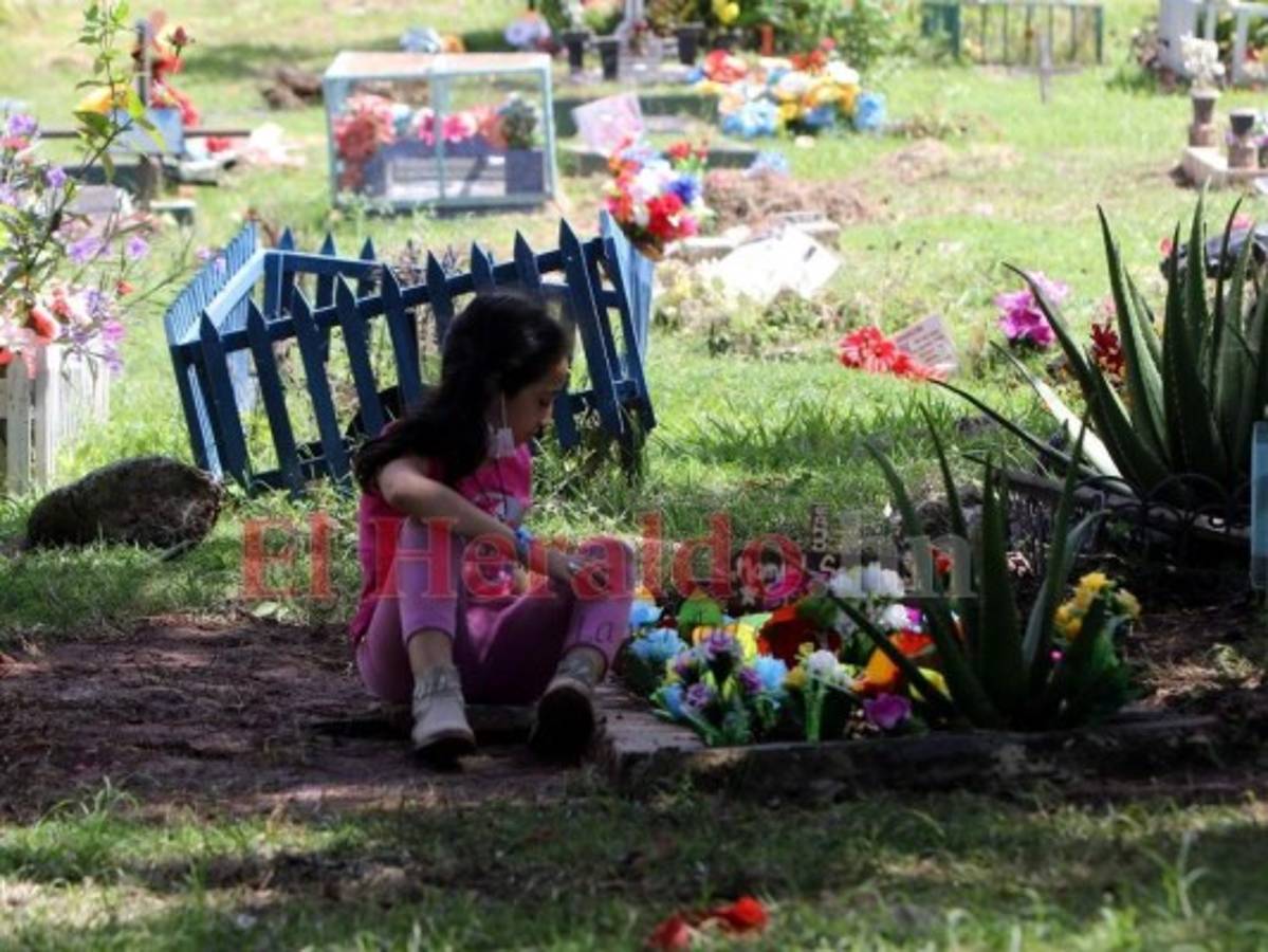 Una niña observa la tumba donde descansa su hermano Manuel.