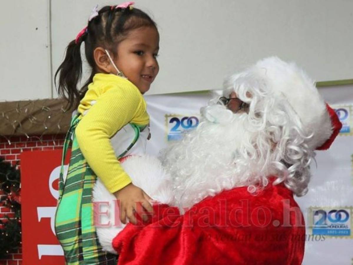 Los más chiquitines fueron los más sorprendidos con la presencia de San Nicolás. Esta pequeña le pidió que la cargara y se mantuvo atenta a que sus padres guardaran el momento a través de una fotografía. Foto: Efraín Salgado/El Heraldo