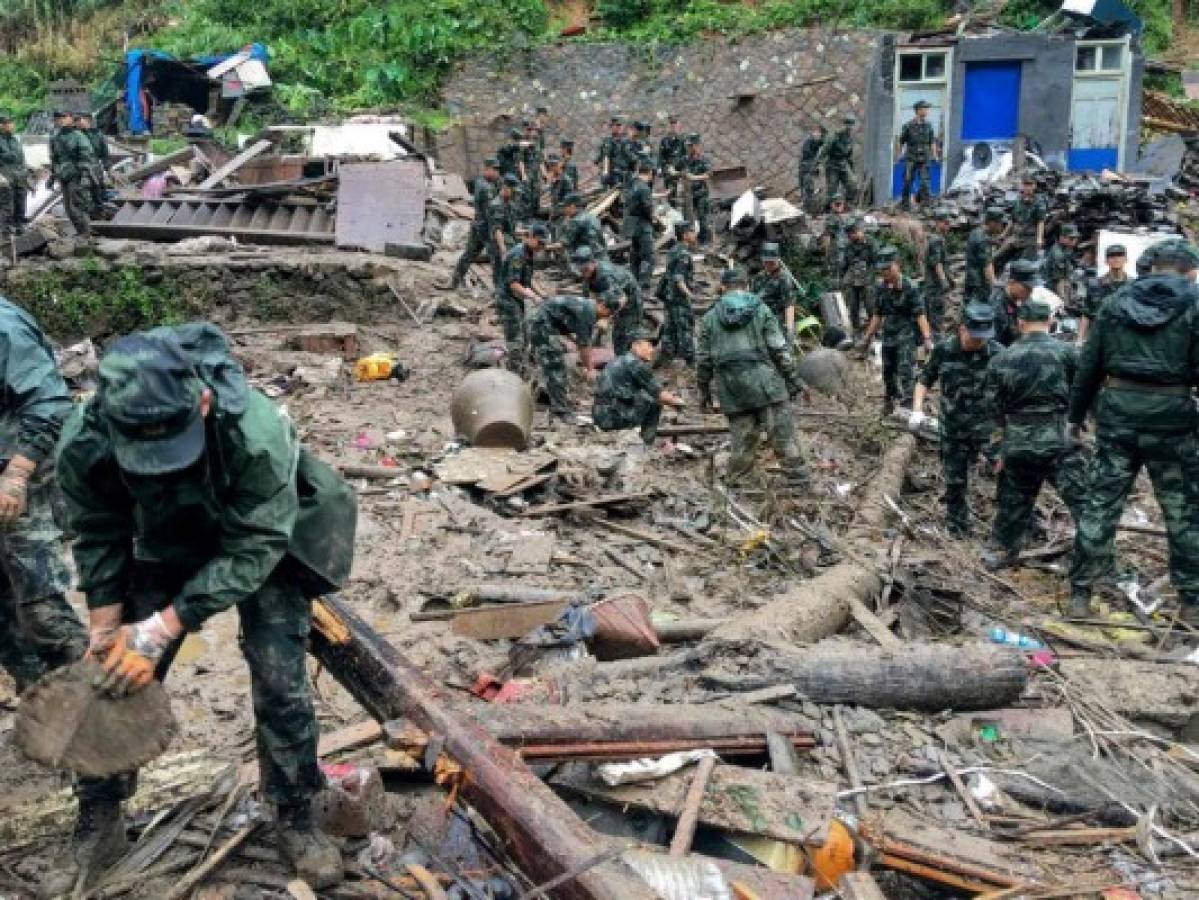 Rescuers look for survivors in the rubble of damaged buildings after a landslide caused by torrential rain from Typhoon Lekima, at Yongjia, in Wenzhou, in China's eastern Zhejiang province on August 10, 2019. - At least 18 people were killed and 14 others missing as Typhoon Lekima lashed eastern China on August 10, downing thousands of trees and forcing more than a million people from their homes. (Photo by STR / AFP) / China OUT