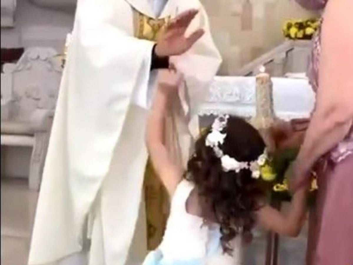 VIDEO: Niña confunde la bendición de sacerdote con 'choca los cinco'