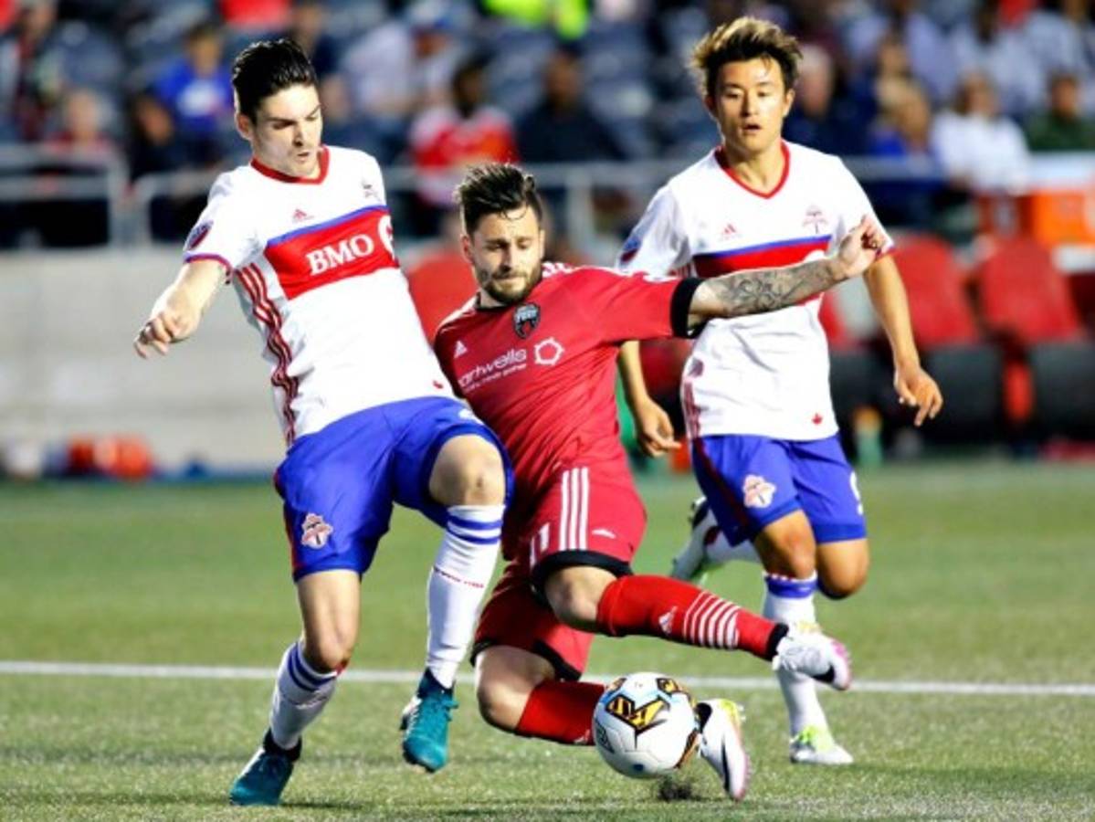 Sito Seoane del Ottawa Fury en lucha con Mitchell Taintor del Toronto FC y Tsubasa Endoh. Uno de los dos equipos podría ir a la Champions (Patrick Doyle/The Canadian Press via AP).