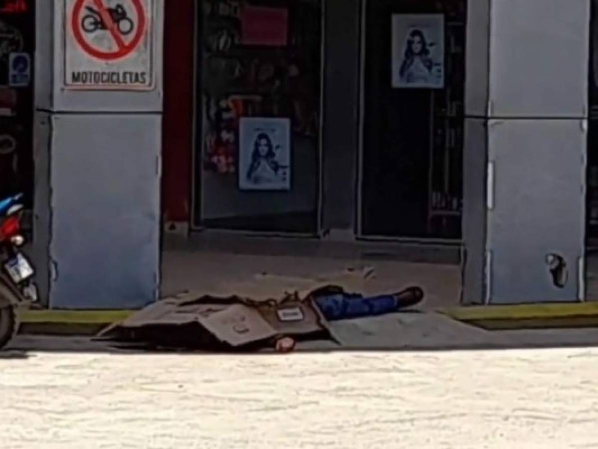 Los locatarios procedieron a cubrir el cadáver con cajas de cartón a la espera de las autoridades. Foto: Cortesía