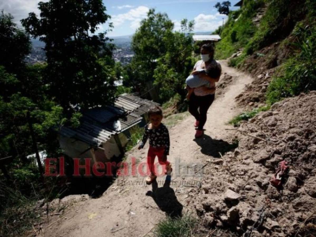 Fany y sus pequeños hijos caminan por uno de los difíciles caminos para llegar al sitio donde una vez estuvo construida su humilde casa. Foto: Emilio Flores/ EL HERALDO.