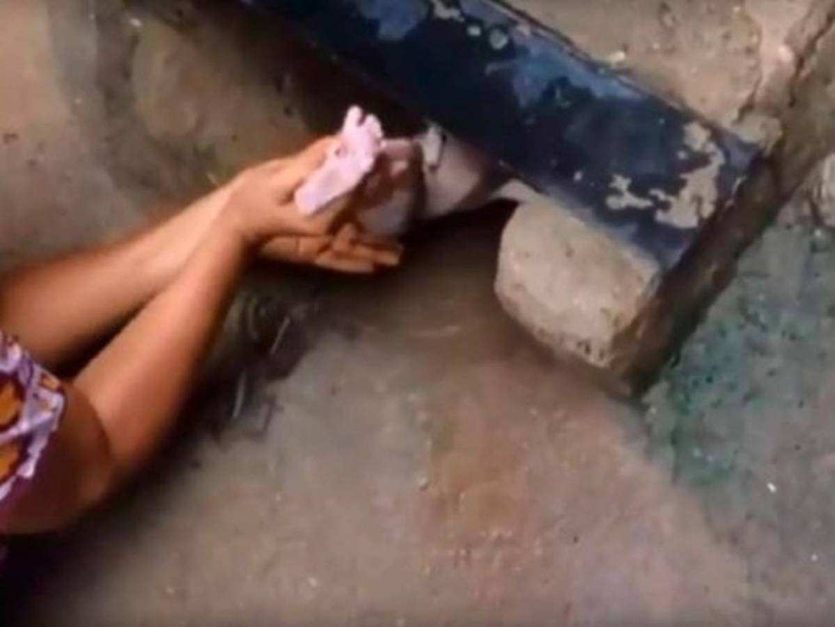Momento en el que rescatan a la bebé que fue abandonada dentro de una alcantarilla.