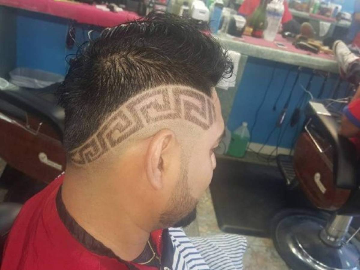 Josué Orellana hace en la cabeza de sus clientes el diseño que le soliciten en la barbaría donde labora.