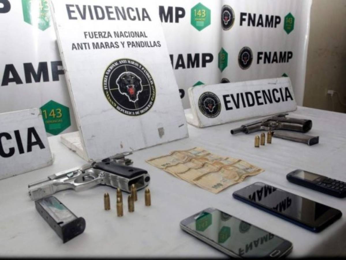 Sobre la mesa de evidencias se observan las armas, el dinero y los proyectiles que se les decomisó a los sospechosos.