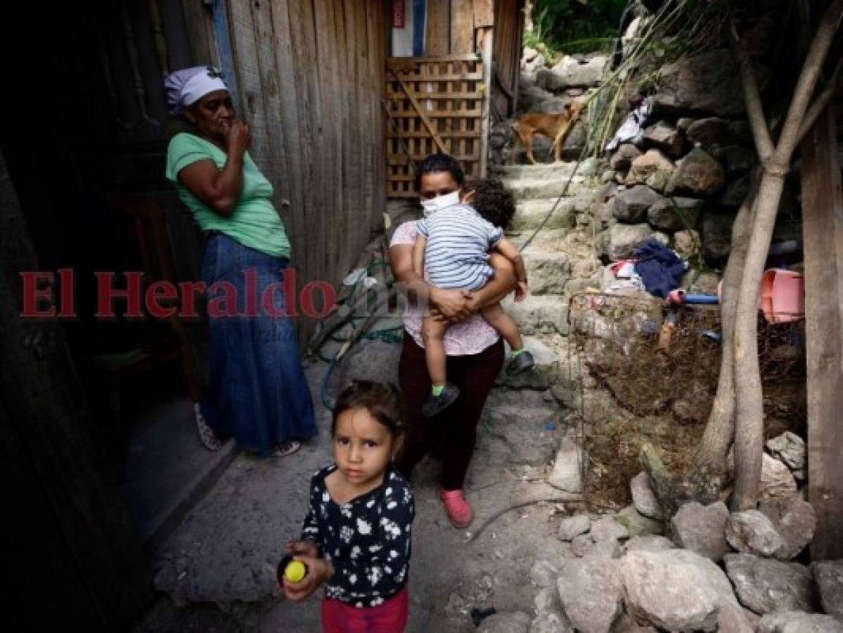 Doña Ana ve con impotencia a su hija Fany y a sus nietos, quien ante la falta de un techo deben vivir dentro de una bodega donde se almacenan fardos de ropa. Foto: Emilio Flores/ EL HERALDO.