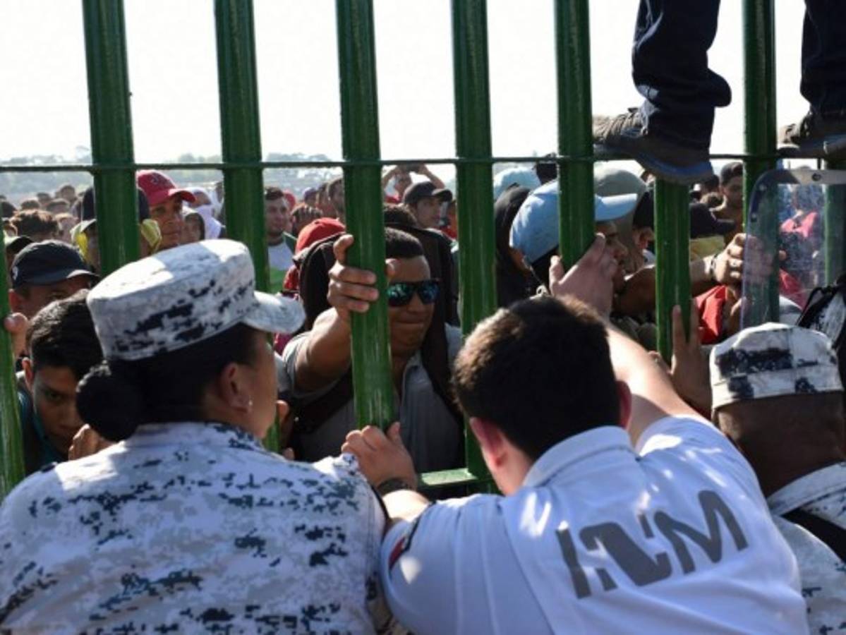 Tras forcejear con agentes, algunos migrantes empiezan a ingresar a México