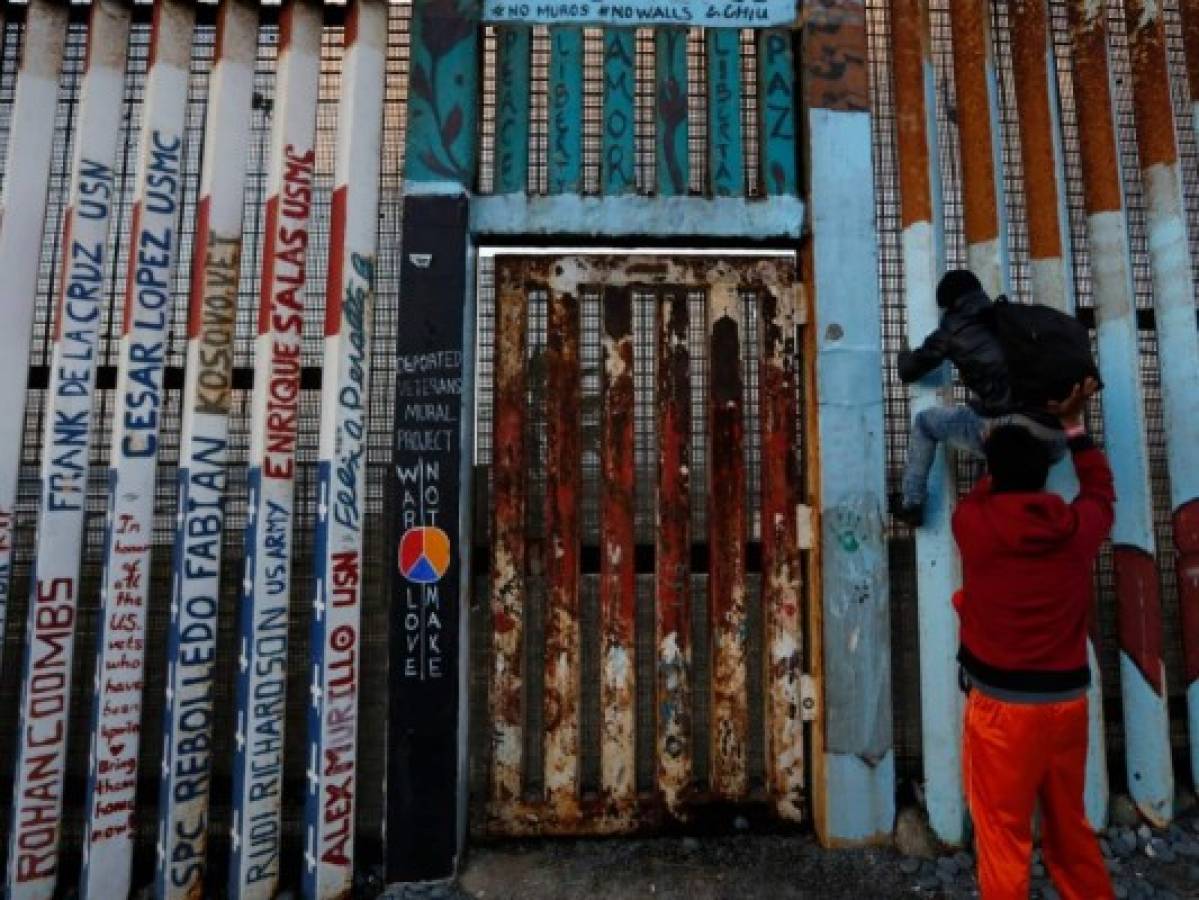 Hondureños en caravana desesperados por ingresar a EEUU saltan muro fronterizo