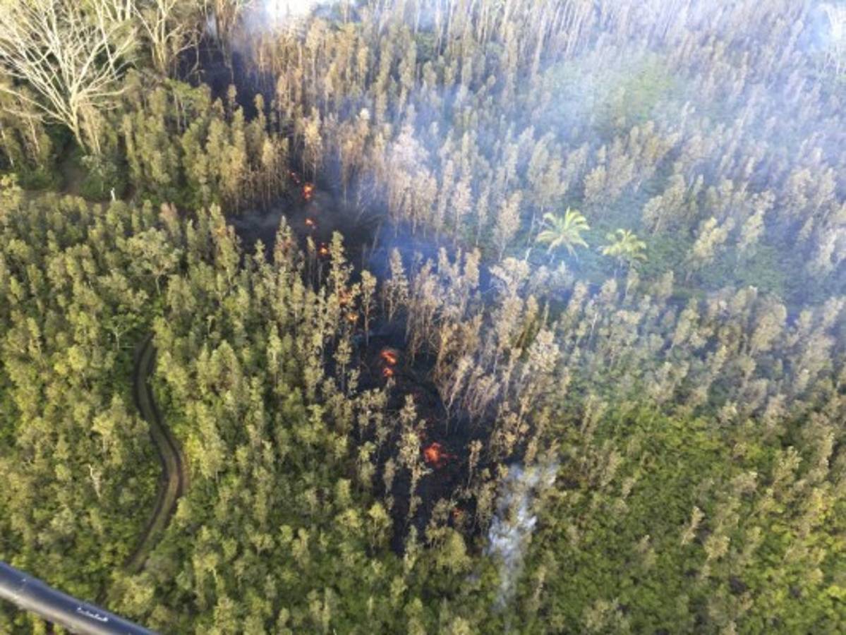 In this photo released by U.S. Geological Survey, lava is shown burning in Leilani Estates subdivision near the town of Pahoa on Hawaii's Big Island Thursday, May 3, 2018 in Hawaii Volcanoes National Park. Kilauea volcano erupted Thursday, sending lava shooting into the air in the residential neighborhood and prompting mandatory evacuation orders for nearby residents. (U.S. Geological Survey via AP)
