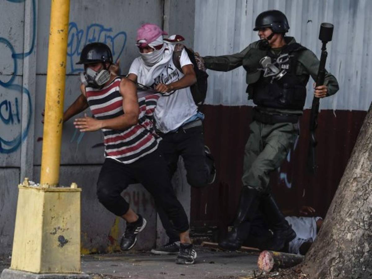 Los protestantes corrían al ser alcanzados por los gases de las bombas lacrimógenas. (AFP)