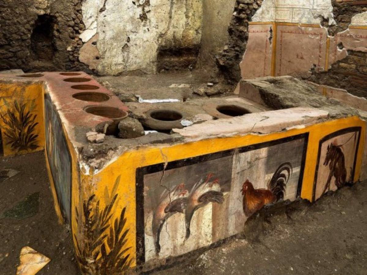 This picture released on December 26, 2020 by the Pompei Press Office shows a thermopolium, a sort of street 'fast-food' counter in ancient Rome, that has been unearthed in Pompei, decorated with polychrome motifs and in an exceptional state of preservation. - The counter frozen by volcanic ash had been partly unearthed in 2019 but the work was extended to best preserve the entire site, located at the crossroads of rue des Noces d'Argent and rue des Balcons. (Photo by Luigi Spina / AFP) / RESTRICTED TO EDITORIAL USE - MANDATORY CREDIT 'AFP PHOTO / POMPEI PRESS OFFICE' - NO MARKETING NO ADVERTISING CAMPAIGNS - DISTRIBUTED AS A SERVICE TO CLIENTS