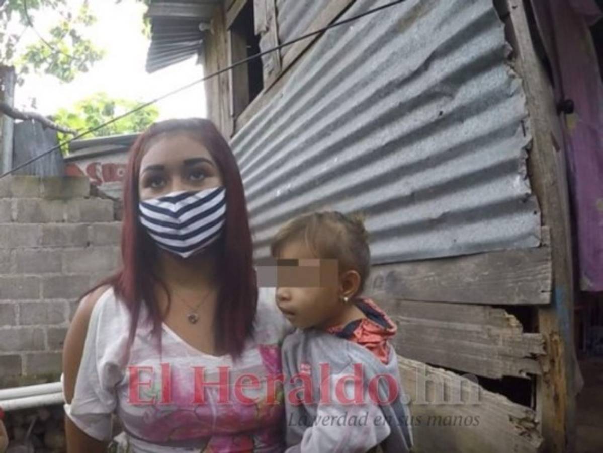 Con su pequeña hija en brazos y de pie junto a las tablas que su padre colocó como paredes luego de que el río Choluteca se llevara parte de la vivienda, Perla conversa con EL HERALDO. Foto: Aarón Canales/ EL HERALDO