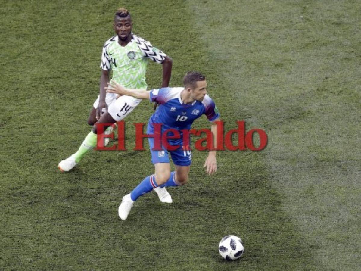 El islandés Gylfi Sigurdsson es desafiado por el nigeriano Kelechi Iheanacho durante el partido del grupo D entre Nigeria e Islandia en la Copa Mundial de fútbol 2018 en el Volgograd Arena de Volgogrado, Rusia. (AP)