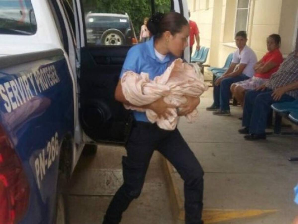 Un miembro de la Policía carga al menor en sus brazos para llevarlo a una supervisión médica.