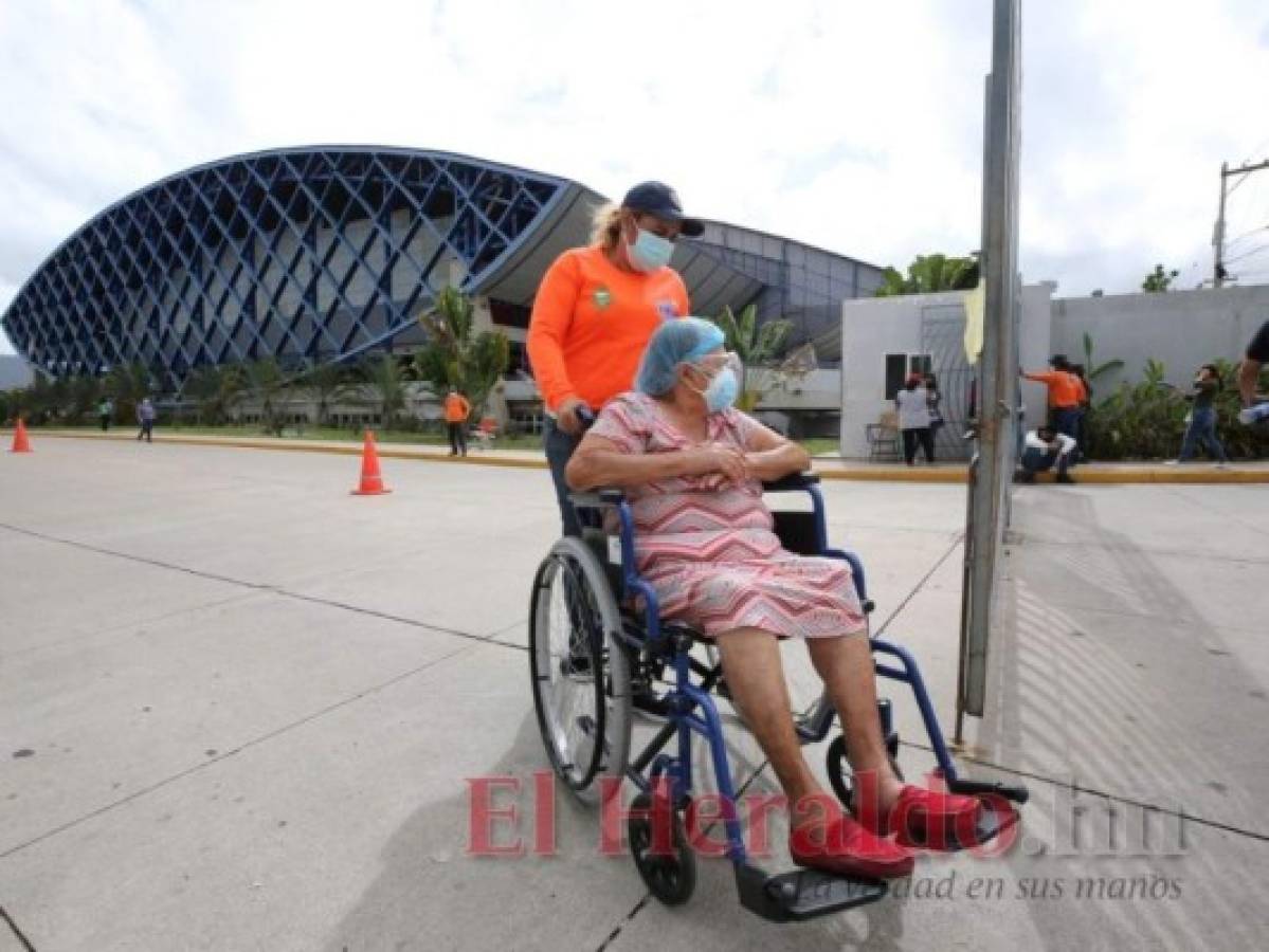 Una adulta mayor llegó en silla de ruedas al Polideportivo de la UNAH. Foto: David Romero/El Heraldo
