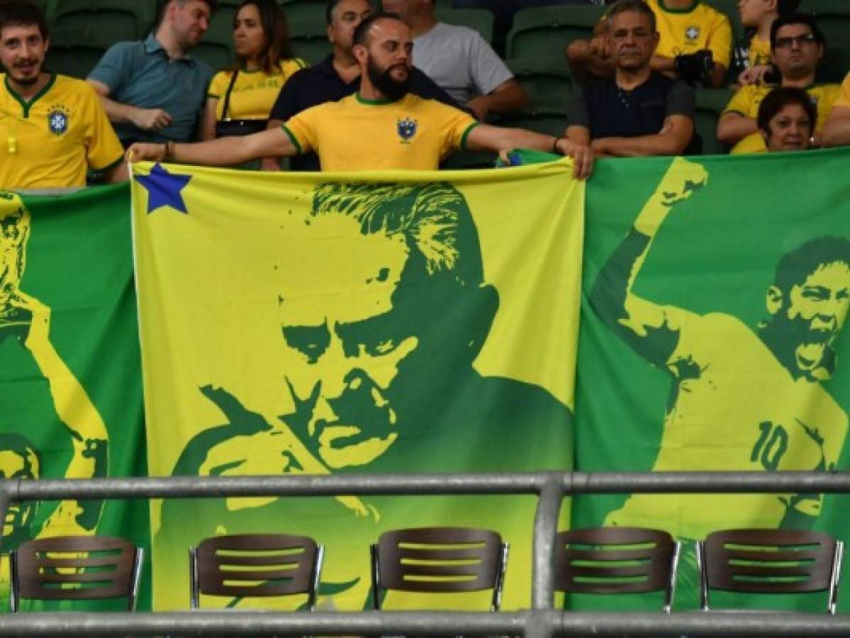 Aficionados de Brasil sostienen una pancarta de ídolos del la Seleçao y el del actual entrenador Tite.