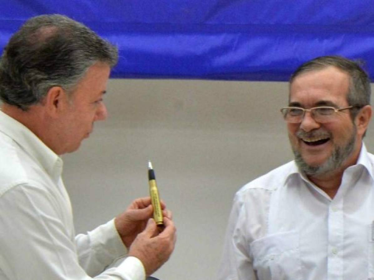 Juan Manuel Santos, presidente de Colombia entrega al comandante de las FARC, una bala convertida en pluma con la que se firmó el acuerdo de paz.