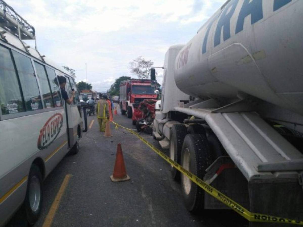 El vehículo pick-up rojo quedó totalmente destruido. Foto cortesía Bomberos Honduras