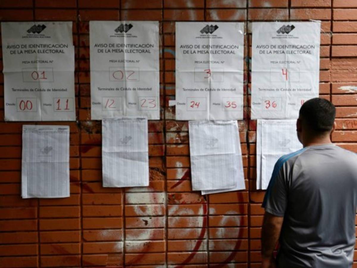 Un hombre se busca en los paderones electorales para ejercer el voto para la aprobar la Constituyente.