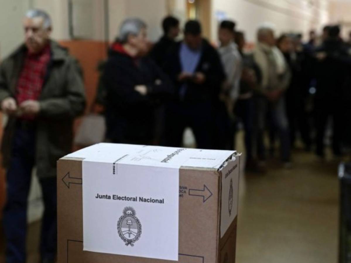 People queue near a ballot box at a polling station during primary elections in Buenos Aires on August 11, 2019. - Primary elections in Argentina take place Sunday, ahead of the October vote. (Photo by ALEJANDRO PAGNI / AFP)