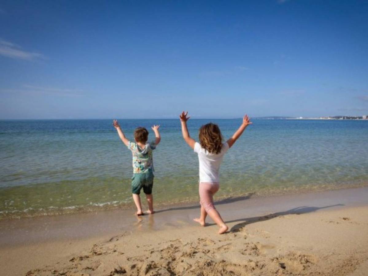 Two children play on the Portixol Beach in Palma de Mallorca, on April 26, 2020 during a national lockdown to prevent the spread of the COVID-19 disease. - After six weeks stuck at home, Spain's children were being allowed out today to run, play or go for a walk as the government eased one of the world's toughest coronavirus lockdowns. Spain is one of the hardest hit countries, with a death toll running a more than 23,000 to put it behind only the United States and Italy despite stringent restrictions imposed from March 14, including keeping all children indoors. Today, with their scooters, tricycles or in prams, the children accompanied by their parents came out onto largely deserted streets. (Photo by JAIME REINA / AFP)
