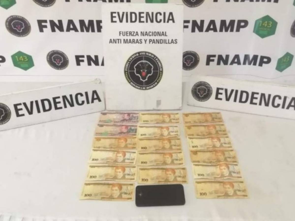Sobre la mesa se muestra la evidencia encontrada al momento de la captura. La Policía asegura que el dinero es producto de la extorsión a varios comercios.