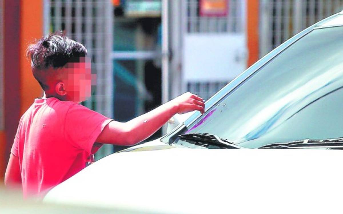 El parpadeo rojo del semáforo es su oportunidad de ganarse la vida