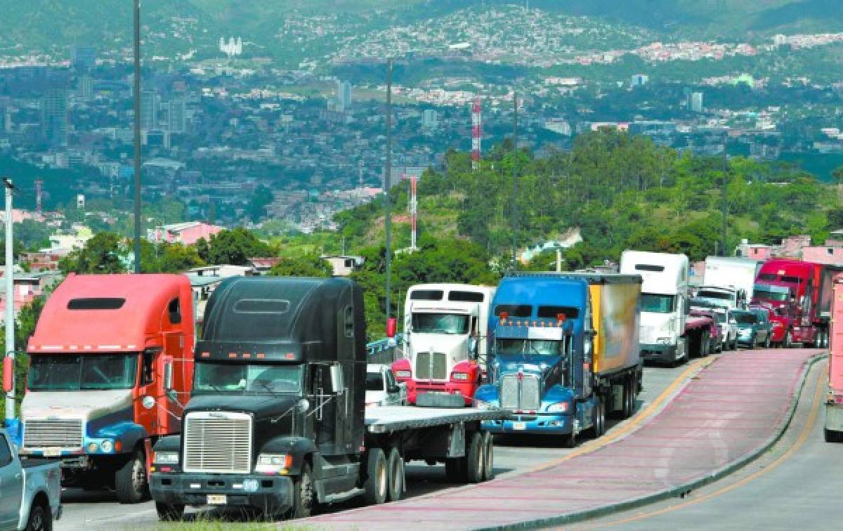 Transporters resume activities after the suspension of the national transport strike in demand of a reduction in the price of fuel, in Tegucigalpa, on July 20 2018. .Public service transporters who blocked roads across Honduras for the second consecutive day, demanding the government of President Juan Orlando Hernandez a reduction in the price of fuel, decided to resume activities and continue negotiating. / AFP PHOTO / ORLANDO SIERRA