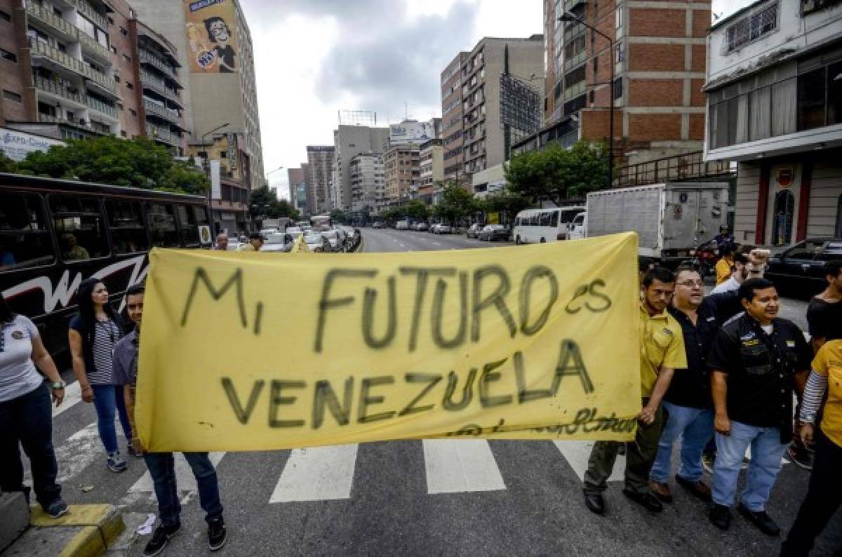Venezuelan opposition activists march along a street of Caracas on March 31, 2017 chanting slogans against the government of President Nicolas Maduro and deploying a banner that reads 'My Future Is Venezuela'.Venezuela's Supreme Court took over legislative powers Thursday from the opposition-majority National Assembly, whose speaker accused leftist President Nicolas Maduro of staging a 'coup.' / AFP PHOTO / Juan Barreto