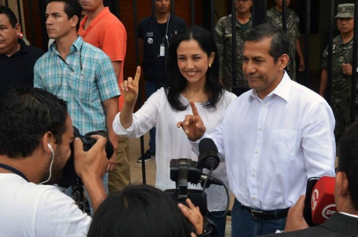 (FILES) This file photo taken on April 10, 2016 shows Peruvian President Ollanta Humala and First Lady Nadine Heredia gesturing after voting in Lima during general elections.A Peruvian judge on July 13, 2017 sentenced former President Humala and his wife to 18 months of preventive prison for money laundering. / AFP PHOTO / CRIS BOURONCLE