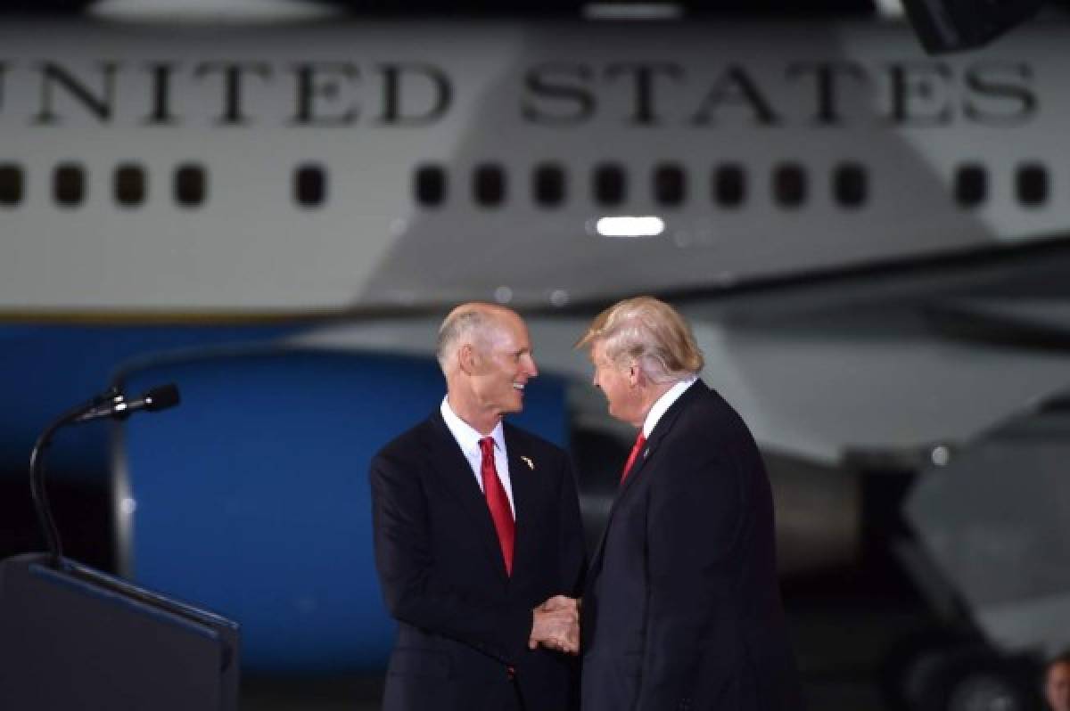 US President Donald Trump greets Governor of Florida, Rick Scott during a campaign rally in Pensacola, Florida on November 3, 2018. (Photo by Nicholas Kamm / AFP)
