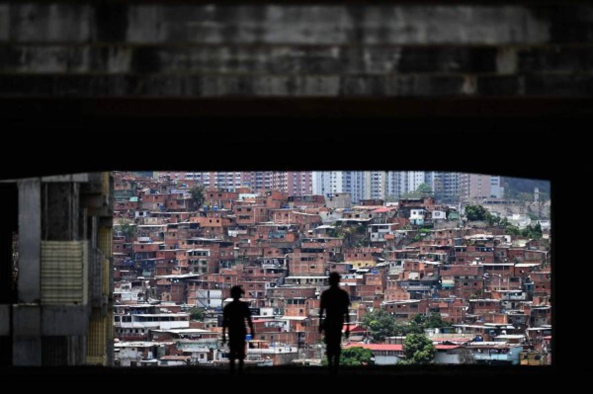 A man and his remain on the roof of the Jehova Gire shelter, a half-done building of the judiciary in Petare neighborhood, Caracas on May 19, 2019. - Symbol of squatting since the time of the late Venezuelan President Hugo Chavez (1999-2013), the concrete skeleton is the home of indigents, victims of disasters and others who fell in disgrace with the worst economic crisis in the recent history of the oil-producing country. (Photo by MARVIN RECINOS / AFP)
