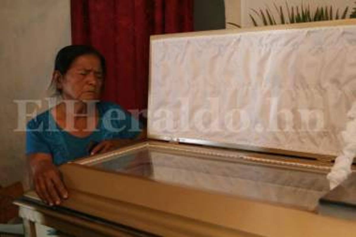 Doña Leonor Villalta se aferra al cajón donde descansa su esposo Rogelio Munguía (Foto: Emilio Flores/ El Heraldo Honduras/ Noticias de Honduras)