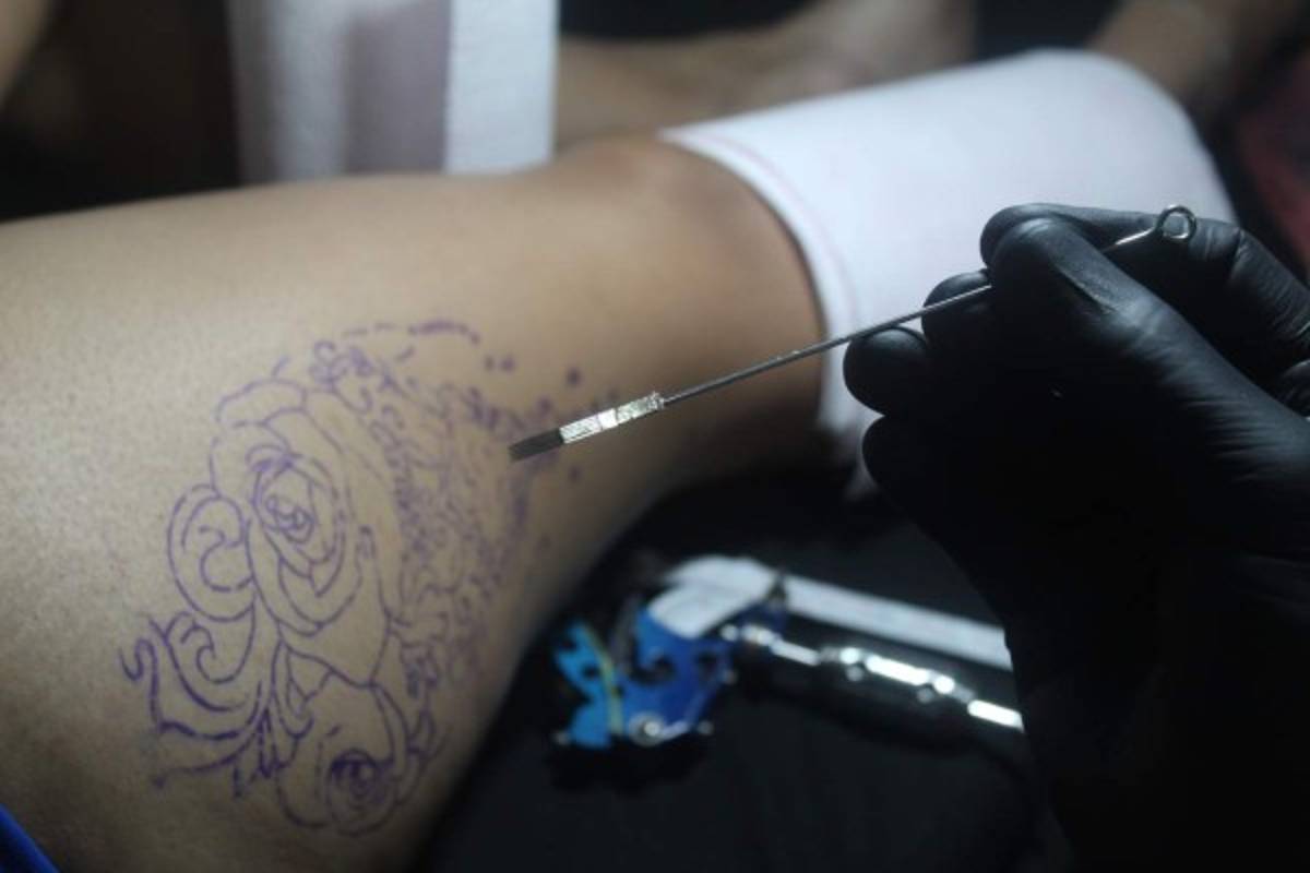 Edgar muestra al cliente la aguja recién salida de su paquete como garantía de sanidad.