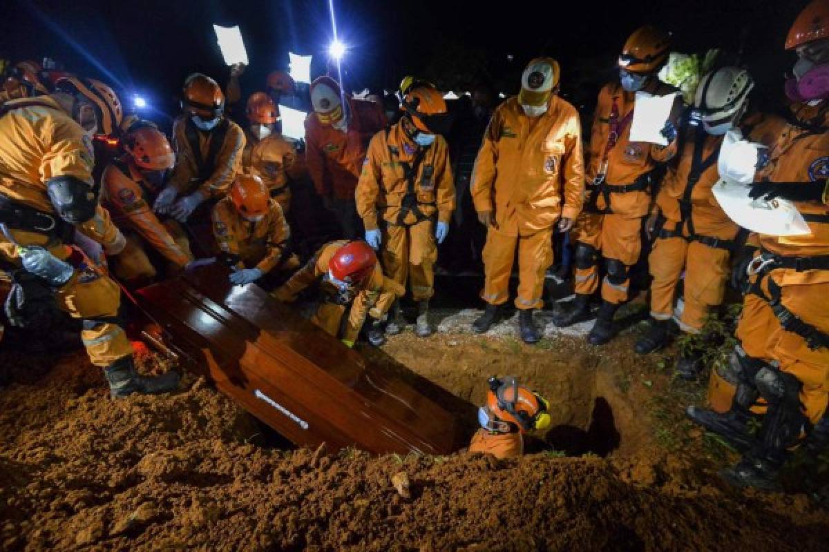 Colombian civil defense workers bury the coffin of Jesus Diago, 33, who died rescuing his family during a mudslide caused by heavy rains, at his funeral in the cementery in Mocoa, Putumayo department, southern Colombia on April 4, 2017. The Colombian government on Monday declared a state of economic emergency in the town of Mocoa in southern Colombia, after mudslides left more than 270 people dead, including 43 children. / AFP PHOTO / LUIS ROBAYO