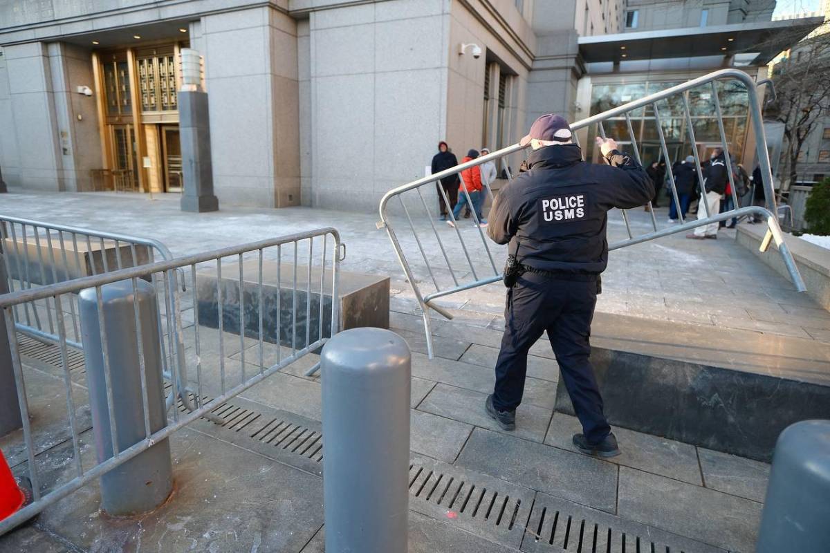 Agentes policiales colocando vallas de seguridad con el fin de evitar disturbios y garantizar el orden en las afueras de la Corte.