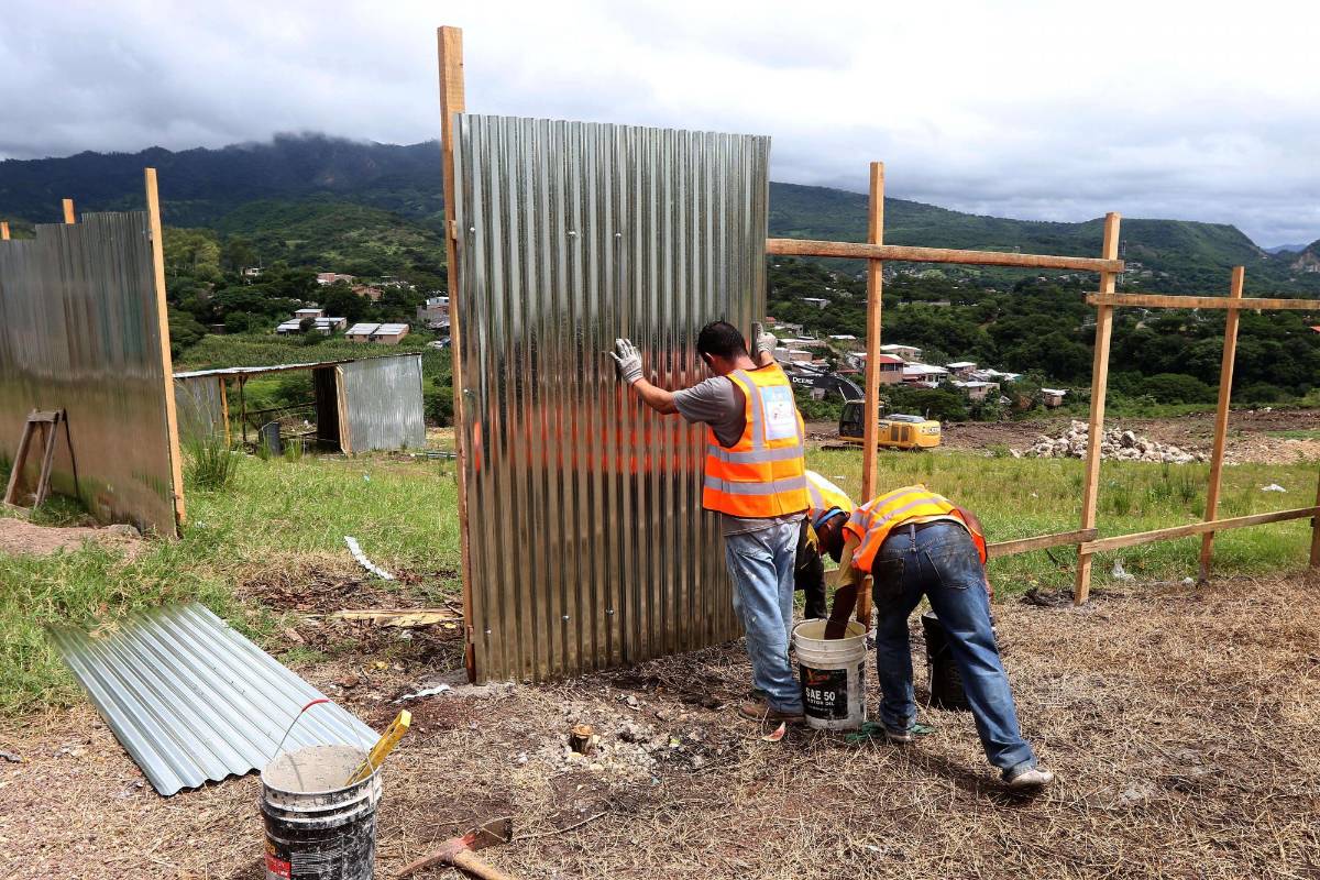 Los trabajadores están cerrando el predio con láminas de zinc y palos.