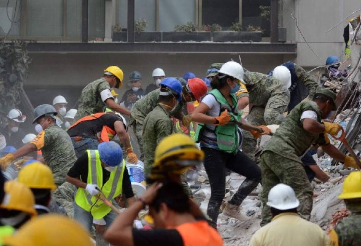 Voluntarios y rescatistas eliminan escombros de un edificio aplanado en la ciudad de México el 21 de septiembre de 2017, mientras que la búsqueda de sobrevivientes continúa dos días después de que un fuerte terremoto golpeó el centro de México. / AFP / Luis Manuel PEREZ