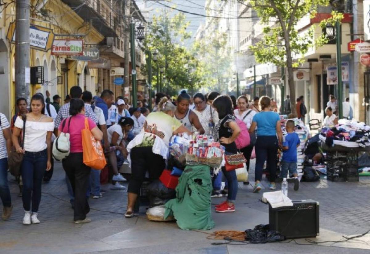 Vendedores ambulantes con vía libre para ofrecer productos en la peatonal de la capital de Honduras