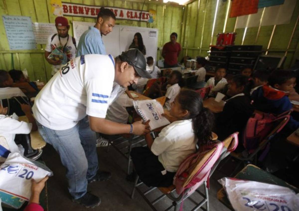 Los voluntarios del programa de Becas 20/20 entregan útiles y alimentos.